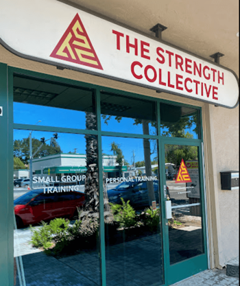 the front window of the strength collective with a sign in the window and a small